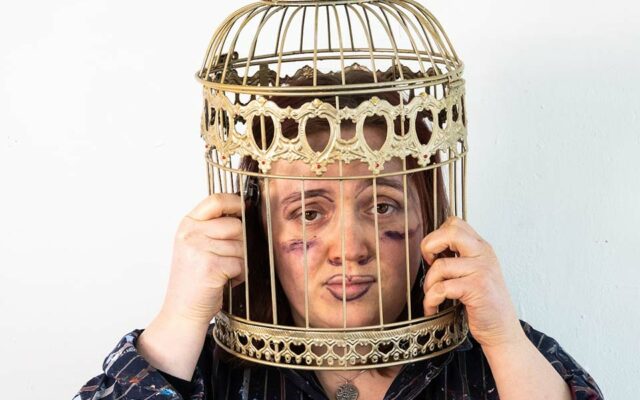 Woman with head in bird cage