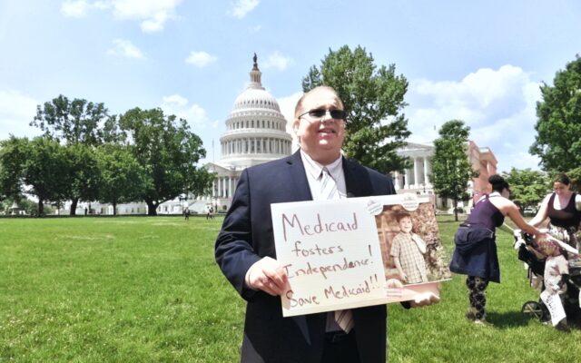 Man holding 'Save Medicaid' sign outside US Capitol