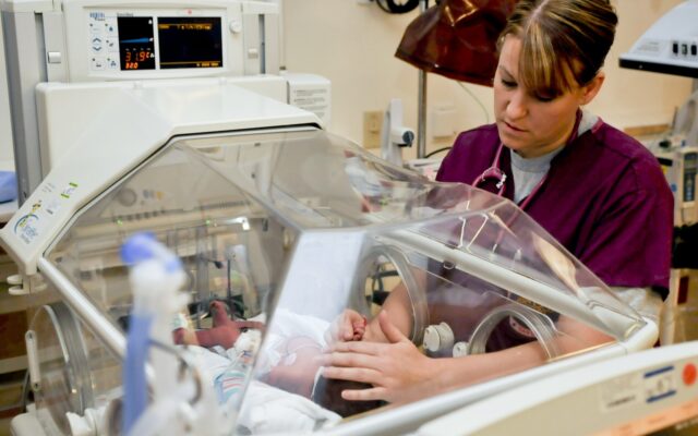 Nurse examining newborn baby in hospital