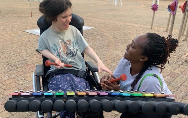 Elvi makes music with a support worker